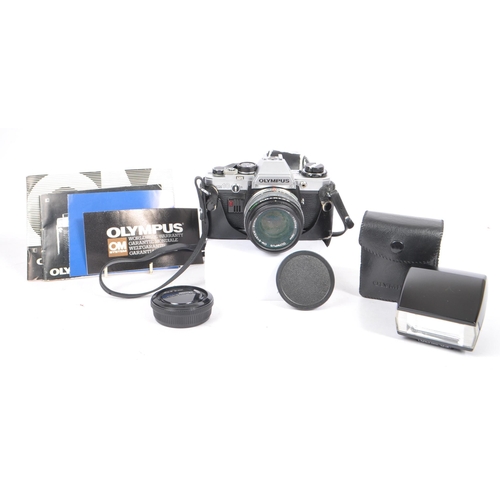 213 - Olympus - A late 20th century circa 1980s OM10 35mm SLR camera with lens and accessories. The camera... 