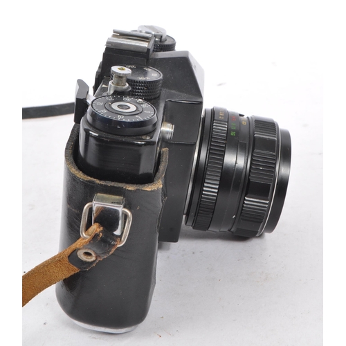 216 - Zenit - A mid 20th century Zenit / Zenith 12XP 35mm SLR camera. The camera having a black body in or... 