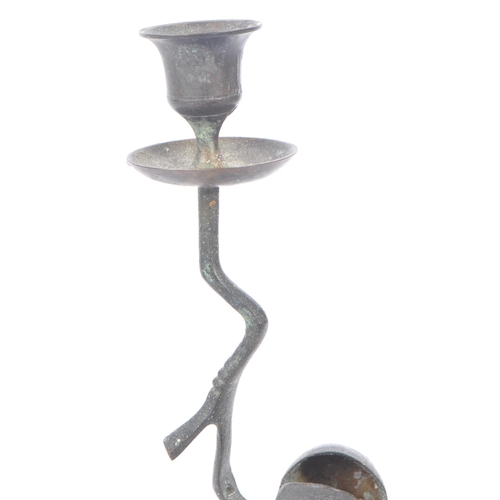 219 - A bronze hollow candlestick holder in the form of a frog standing on leaf base with arm raised holdi... 