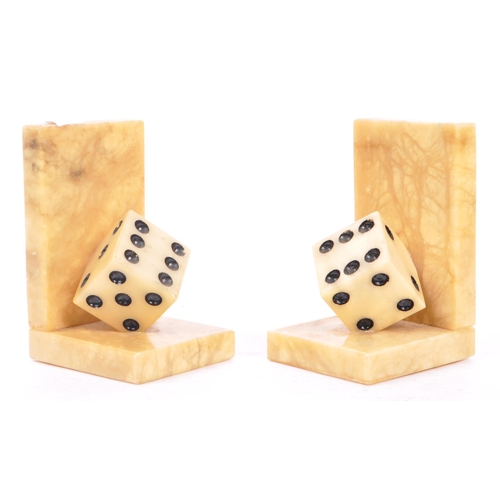 223 - A pair of mid 20th century alabaster dice bookends. The bookends each of L shape, with carved alabas... 