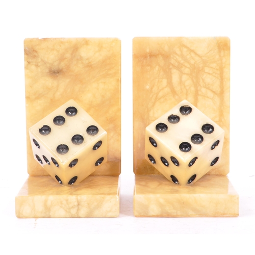 223 - A pair of mid 20th century alabaster dice bookends. The bookends each of L shape, with carved alabas... 