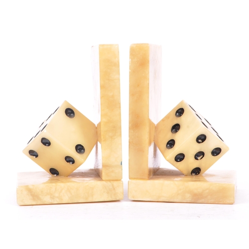 223 - A pair of mid 20th century alabaster dice bookends. The bookends each of L shape, with carved alabas... 