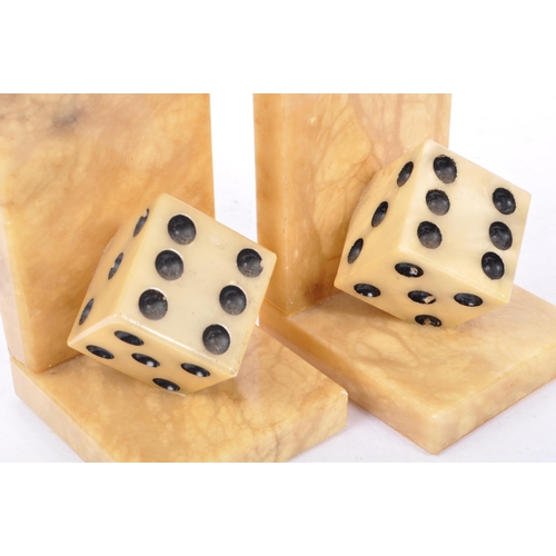 223 - A pair of mid 20th century alabaster dice bookends. The bookends each of L shape, with carved alabas... 