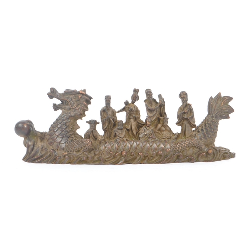 229 - Two Chinese bronze figure ornaments. One fuk luk sau in a dragon boat on a naturalistic sea base, to... 