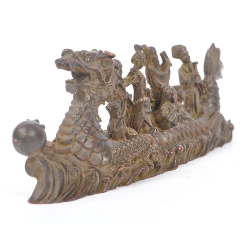 229 - Two Chinese bronze figure ornaments. One fuk luk sau in a dragon boat on a naturalistic sea base, to... 