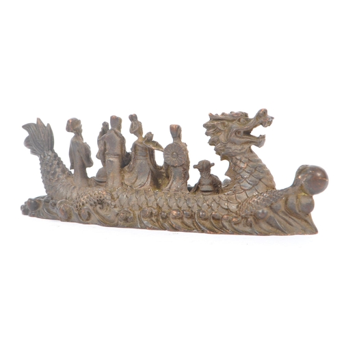 229 - Two Chinese bronze figure ornaments. One fuk luk sau in a dragon boat on a naturalistic sea base, to... 