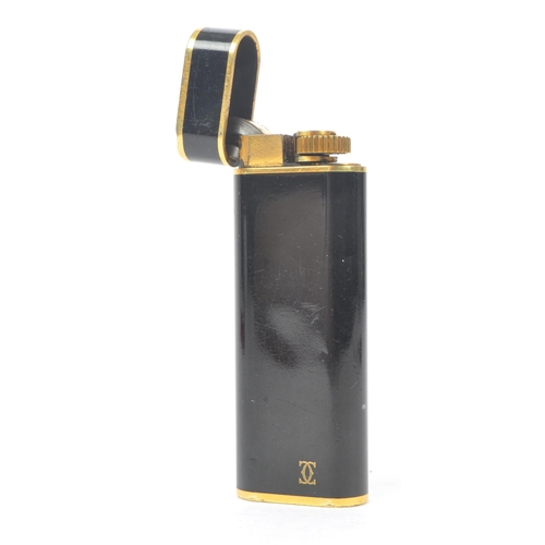 237 - A 20th Century French vintage Must de Cartier Paris 'Trinity' black lacquer and gold plated lighter ... 