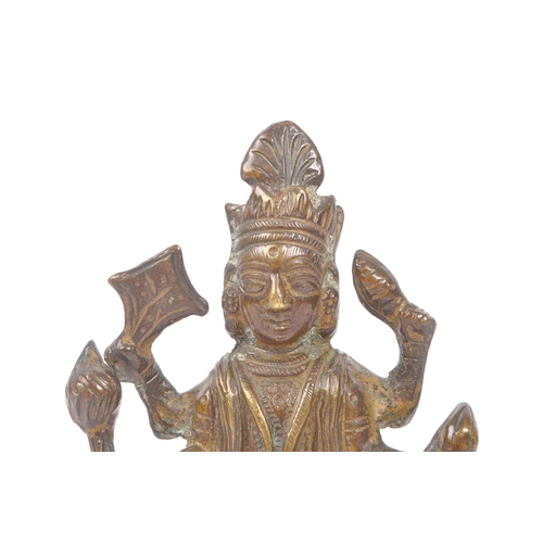 243 - A small brass Indian figure in the form of the Hindu God Vishnu depicted with four arms, heavily jew... 