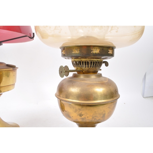 244 - Two vintage 20th century brass table oil lamps. Having glass flutes, with circular shades on brass s... 