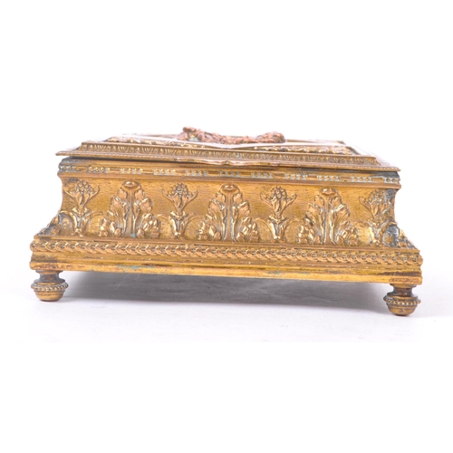 256 - A 19th Century French brass hinged ornamental jewellery box of square form having central vignette d... 