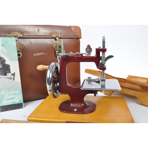 270 - Essex - A vintage mid 20th century Essex miniature sewing machine. The machine held within a leather... 