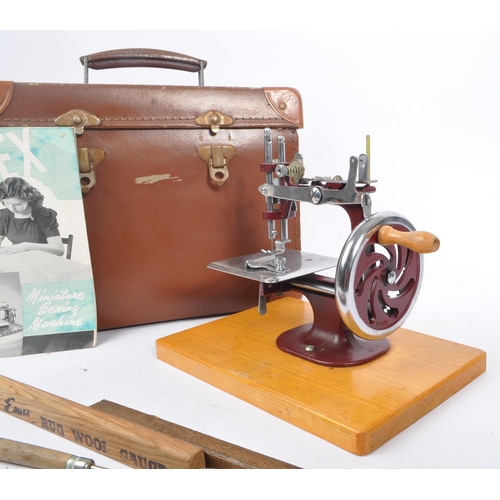 270 - Essex - A vintage mid 20th century Essex miniature sewing machine. The machine held within a leather... 