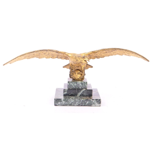 281 - A 20th Century ormolu bronze gilt eagle figure with wings spread and clawed feet holding a ball atop... 