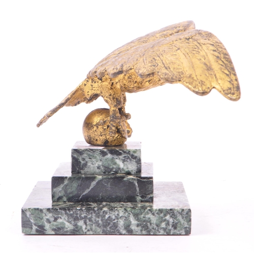 281 - A 20th Century ormolu bronze gilt eagle figure with wings spread and clawed feet holding a ball atop... 