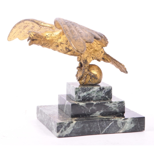 281 - A 20th Century ormolu bronze gilt eagle figure with wings spread and clawed feet holding a ball atop... 