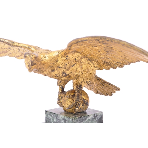 281 - A 20th Century ormolu bronze gilt eagle figure with wings spread and clawed feet holding a ball atop... 