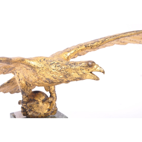 281 - A 20th Century ormolu bronze gilt eagle figure with wings spread and clawed feet holding a ball atop... 