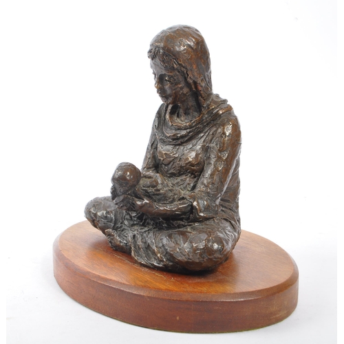 300 - A vintage 20th century spelter figure of female mother holding baby. Female wearing head dress with ... 