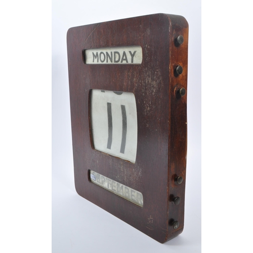 443 - A large early / mid Century wooden wall mounted perpetual calendar of square form, having windows fo... 