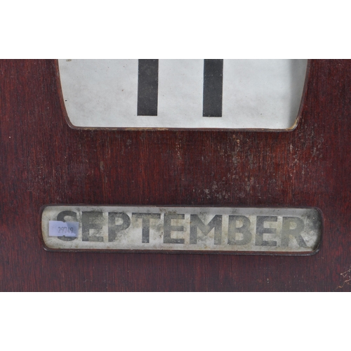 443 - A large early / mid Century wooden wall mounted perpetual calendar of square form, having windows fo... 