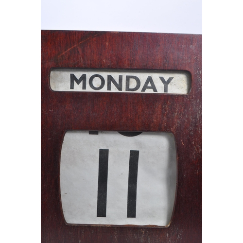 443 - A large early / mid Century wooden wall mounted perpetual calendar of square form, having windows fo... 