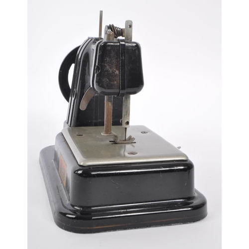 445 - Volcan - Mid 20th century toy tin sewing machine. Made in England with label to side. Black colour w... 