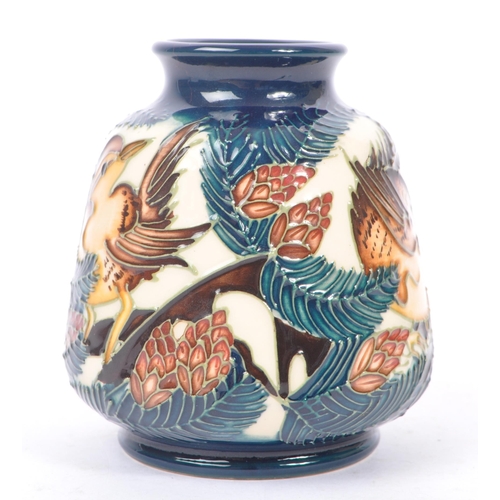 6 - Moorcroft - A china porcelain Moorcroft Pottery small vase in bird and pine tree pattern against cre... 