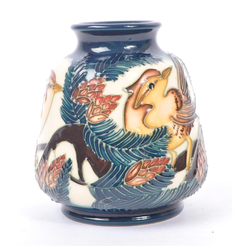 6 - Moorcroft - A china porcelain Moorcroft Pottery small vase in bird and pine tree pattern against cre... 