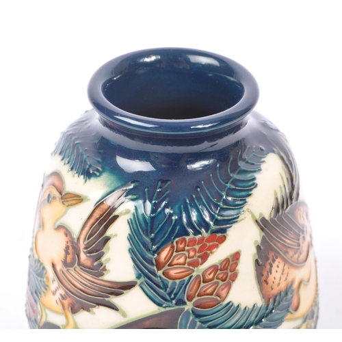 6 - Moorcroft - A china porcelain Moorcroft Pottery small vase in bird and pine tree pattern against cre... 