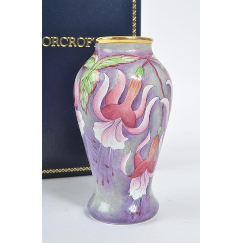 63 - Moorcroft Pottery - A contemporary small proportion vase. Fuchsia flowers with gilt rim. Signed and ... 