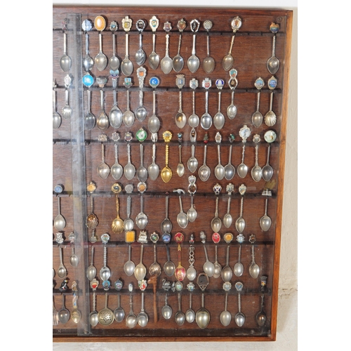 356 - A large collection of 20th century souvenir decorative spoons. The collection housed in a large maho... 