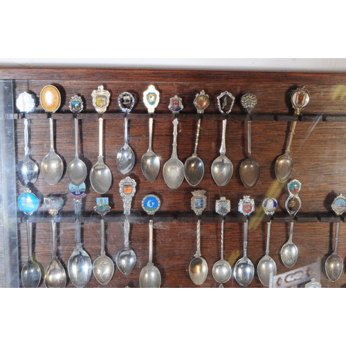 356 - A large collection of 20th century souvenir decorative spoons. The collection housed in a large maho... 