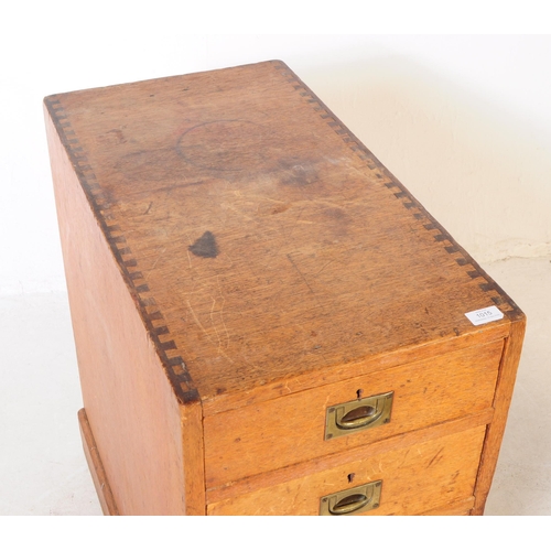 1015 - An early 20th century oak campaign pedestal chest of drawers. Rectangular form with a bank of three ... 