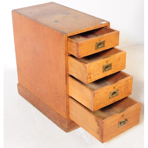 1015 - An early 20th century oak campaign pedestal chest of drawers. Rectangular form with a bank of three ... 