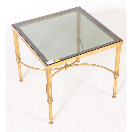 568a - A 20th century Hollywood regency manner brass and smoked glass coffee table. The table of square for... 