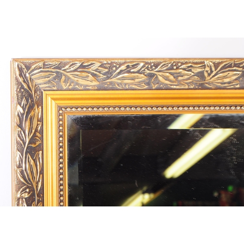 1020 - A large 20th century giltwood and gesso framed overmantle mirror. The mirror having a large central ... 