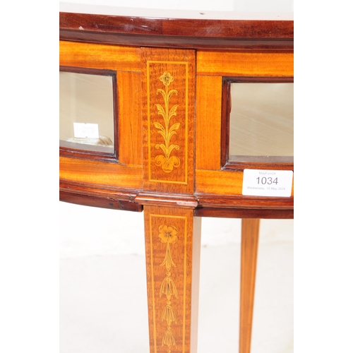 1034 - A 1920s inlaid bijouterie glass display table. Of circular form with glass panel to top, curved glas... 