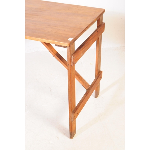 560a - A vintage solid pine wood folding trestle table with cross banded legs. Measures approx. 75cm x 137c... 