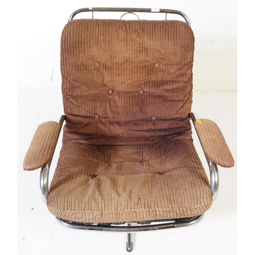 569 - British Modern Design - A retro mid 20th century swivel lounge armchair. Having a brown fabric padde... 