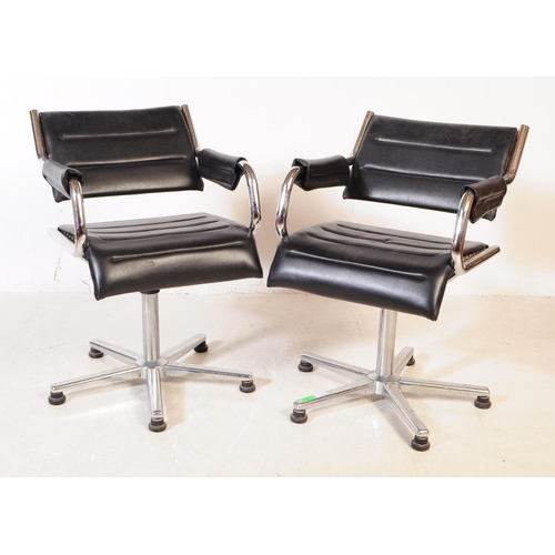 580 - A pair of vintage mid 20th century metal and leatherette chrome office swivel desk chairs. Having a ... 