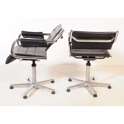 580 - A pair of vintage mid 20th century metal and leatherette chrome office swivel desk chairs. Having a ... 