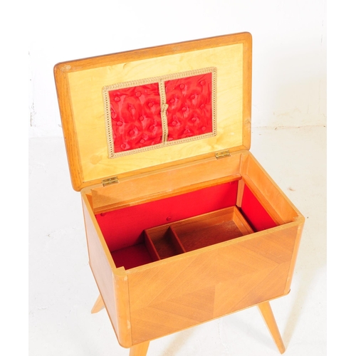 585 - British Modern Design - A mid 20th century oak wood sewing box side table. The sewing box raised on ... 