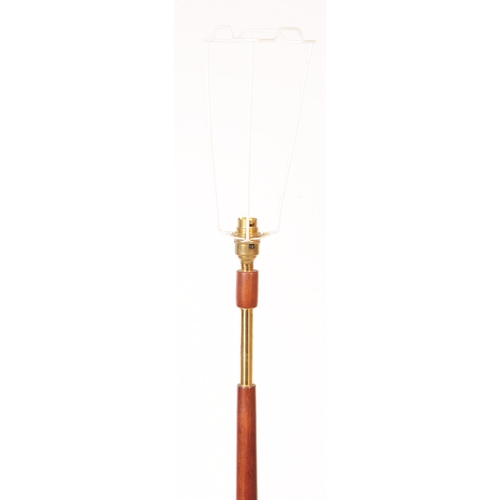 599 - British Modern Design - A mid 20th century teak and brass floor standing standard lamp. The lamp sto... 