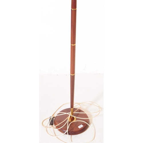 599 - British Modern Design - A mid 20th century teak and brass floor standing standard lamp. The lamp sto... 