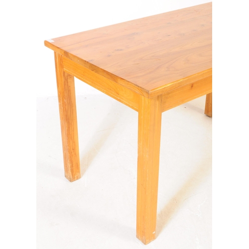 604 - A contemporary pine wood refectory kitchen dining table. The table of rectangular form raised on squ... 