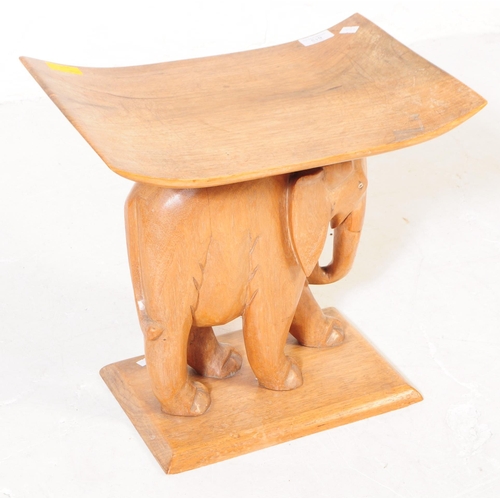 613 - A 20th century carved oak wood elephant stool. The stool in the form of a carved elephant, stood on ... 