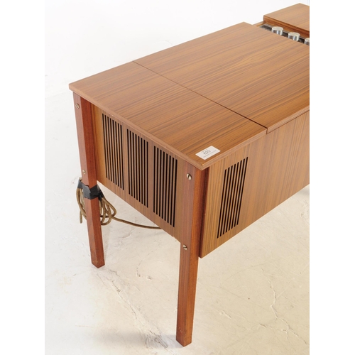 629 - A mid 20th century veneered HMV stereogram. Having hinged top with grill fascia, raised on squared l... 