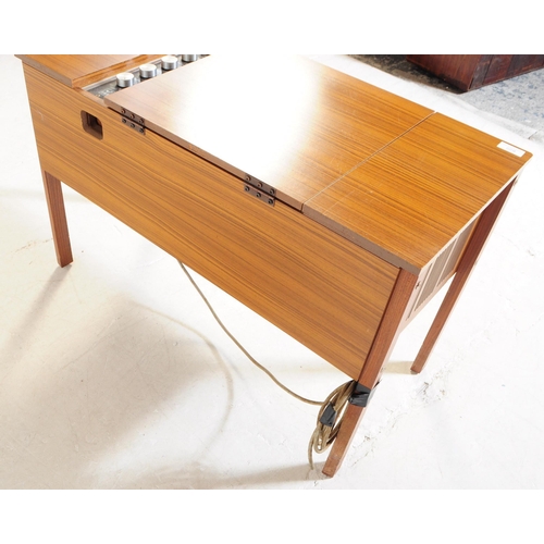 629 - A mid 20th century veneered HMV stereogram. Having hinged top with grill fascia, raised on squared l... 