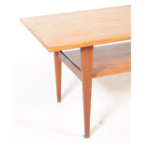 633 - British Modern Design - A mid 20th century teak wood long john coffee table. Raised on tapering legs... 