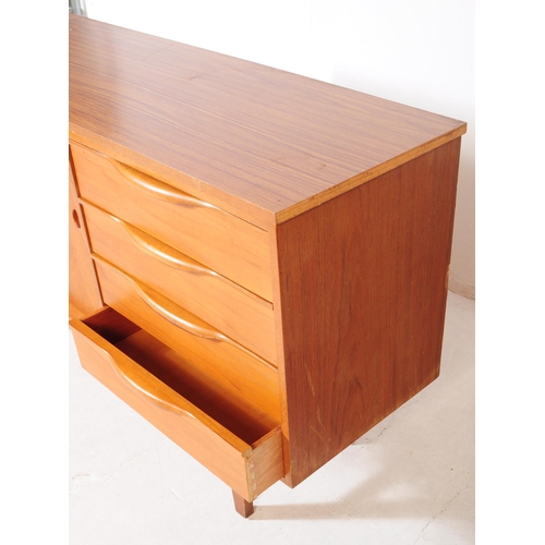 634 - British Modern Design - A mid 20th century teak wood sideboard in the manner of Beautility. Raised o... 